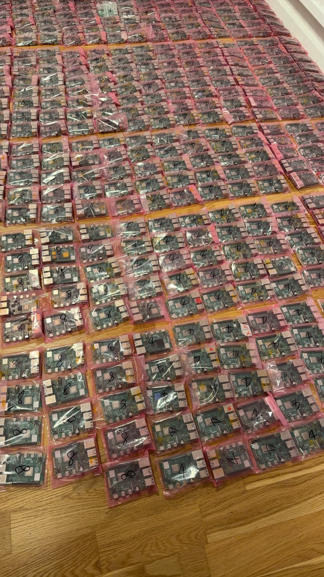 Pink anti-static foam tray of mixed Raspberry Pi boards from a contract assembler burn-in test line