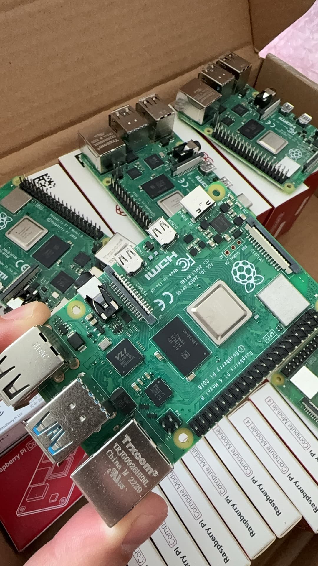 Twelve Raspberry Pi 4B 4GB boards from a cancelled deployment, mix of boxed and bare units